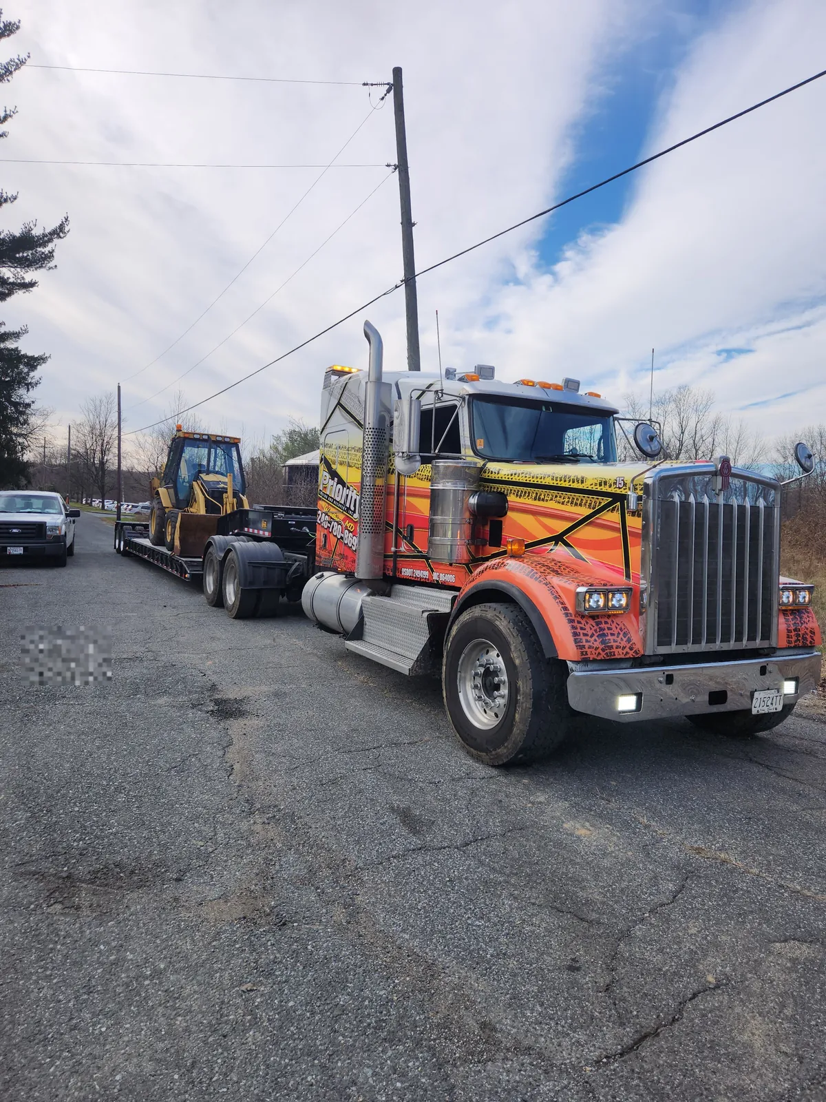 Priority Towing RGN lowboy hauling a loader